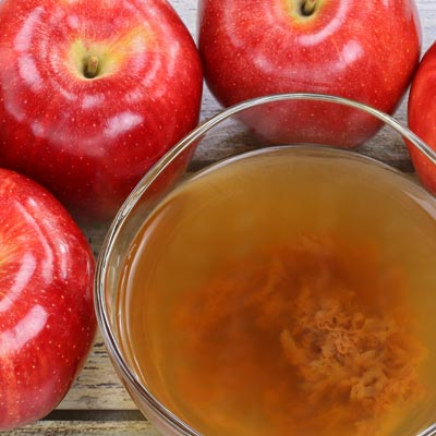 bowl of apple cider and 3 apples