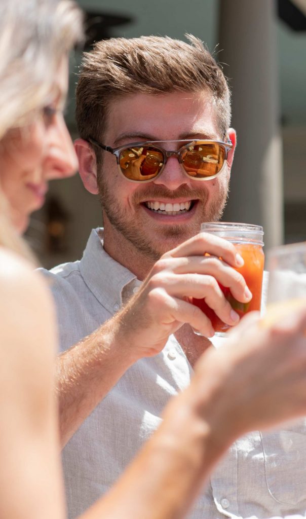 Man in sunglasses holding drink outside
